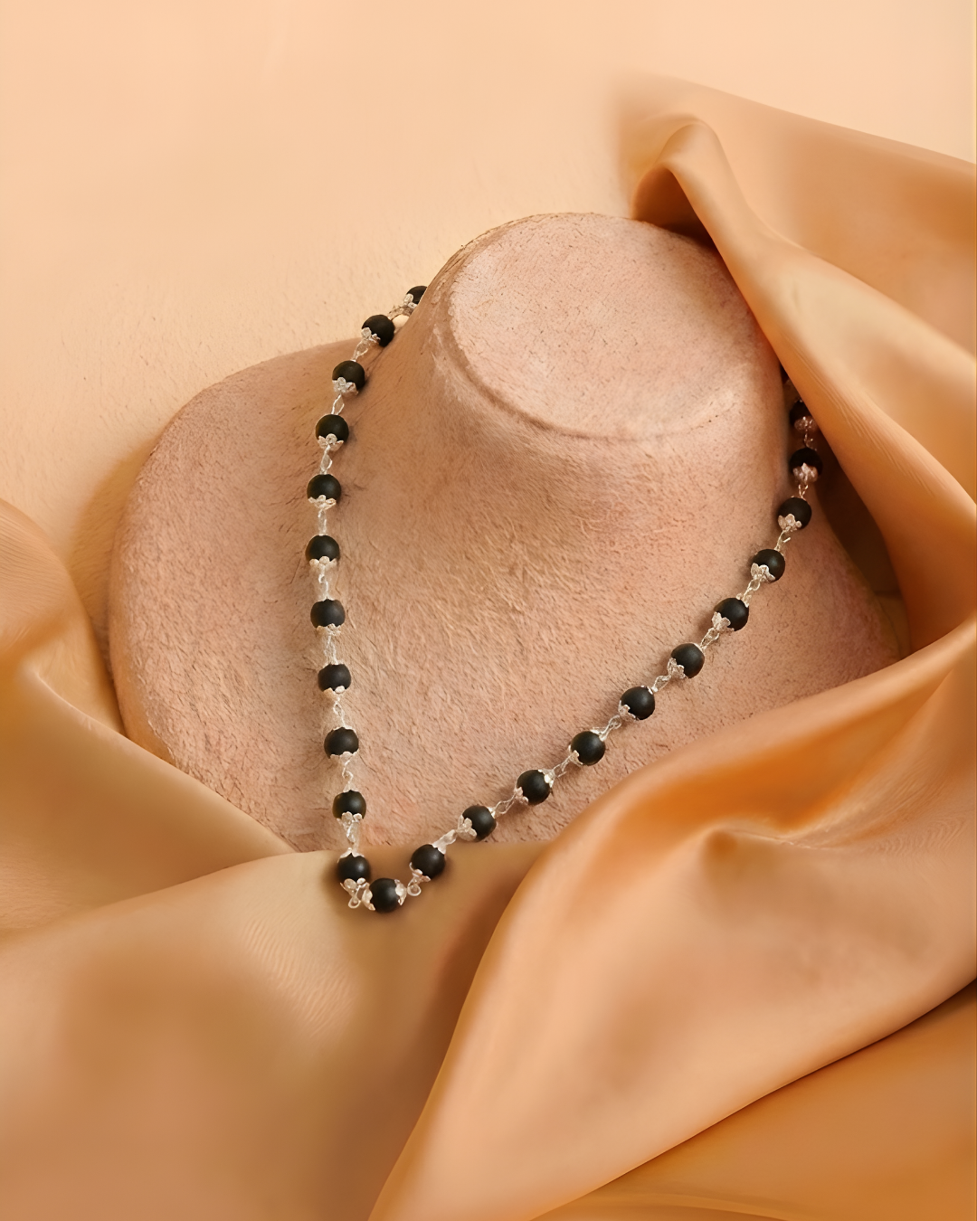 silver karungali mala placed around manequinn